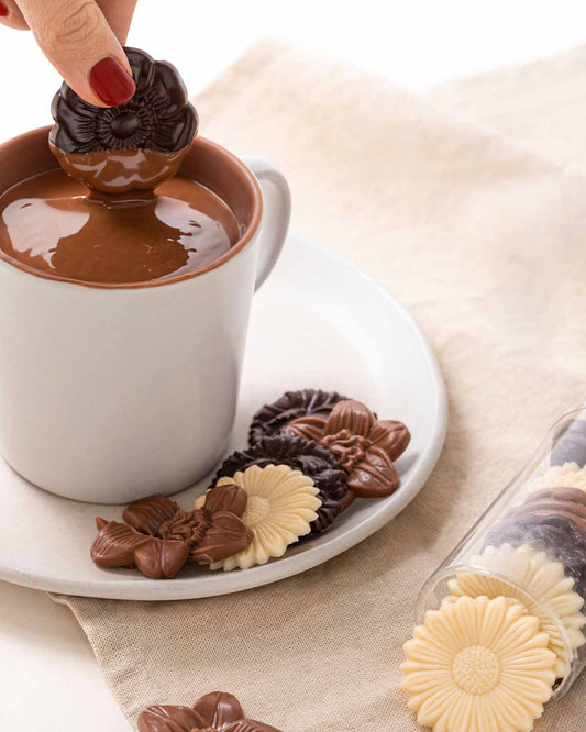 Flores de chocolate surtidas tubo 110g, disponible en presentación a granel.